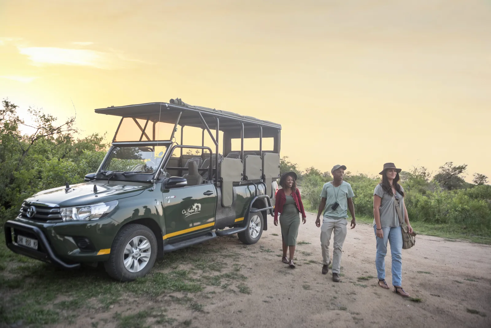 Family beside an open safari vehicle on a guided Kruger National Park game drive